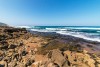 Rocks sand ocean at Mission Rocks beach near Cape Vidal