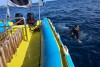 Diver floats in water next to  boat in Sodwana Bay, iSimangaliso Wetlands Park