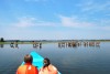 Tourists in a boat look on the antelopes waterbuck, Lake Naivasha
